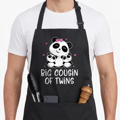 Tablier de cuisine noir avec illustration d'un panda et deux bébés pandas sous le texte Big Cousin of Twins.