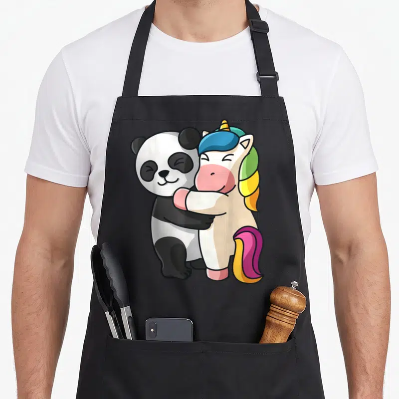 Tablier de cuisine noir avec illustration d'un panda et d'une licorne s'encourageant dans un grand câlin mignon.