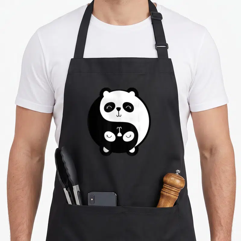 Tablier de cuisine noir avec illustration d'un panda Yin Yang aux yeux fermés et expression douce.