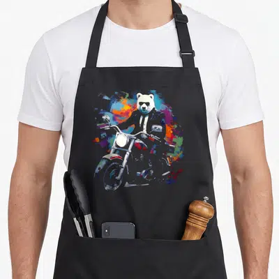 Tablier de cuisine noir avec ours polaire en lunettes de soleil assis sur une moto aux couleurs vives.
