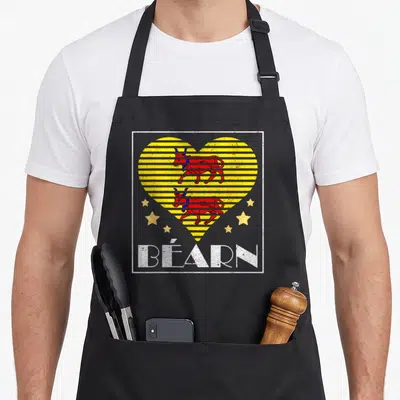 Tablier de cuisine noir avec un cœur jaune strié contenant deux taureaux rouges et linscription BÉARN en bas.