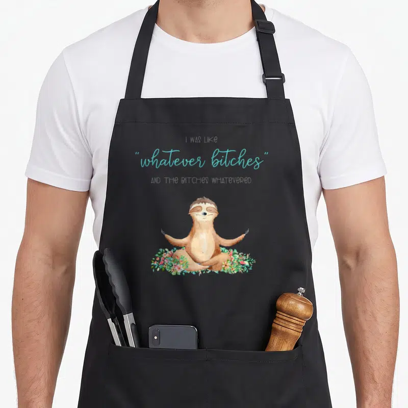 Tablier de cuisine noir avec un paresseux en tailase et le texte whatever bitches en bleu turquoise.