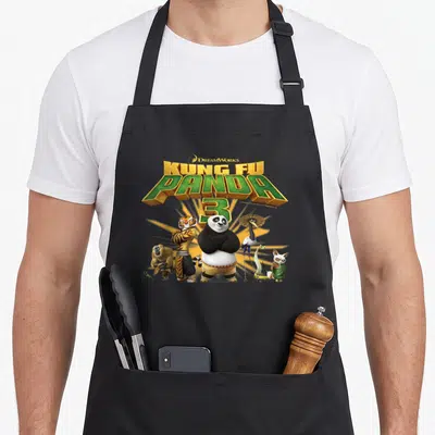 Tablier de cuisine noir avec le logo Kung Fu Panda 3 et les personnages Po, Tigresse et les Cinq Furents.