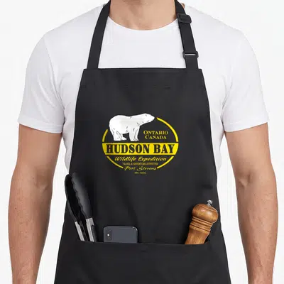 Tablier de cuisine noir avec illustration d'ours polaire et texte Hudson Bay Ontario Canada en jaune et gris.