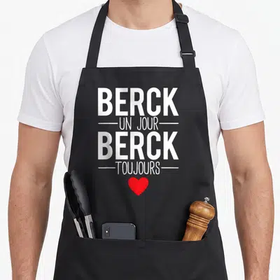 Tablier de cuisine noir avec inscription blanche Berck un jour Berck toujours et un cœur rouge en bas du motif imprimé.