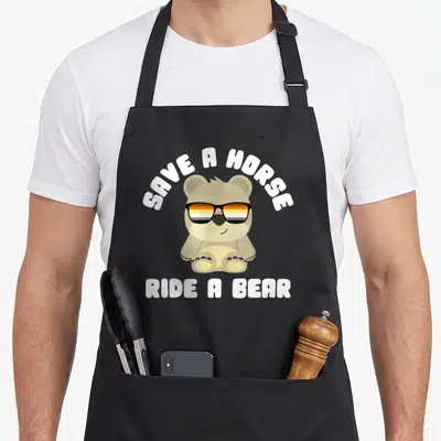 Tablier de cuisine noir avec ours marron portant des lunettes de soleil et texte blanc humoristique.