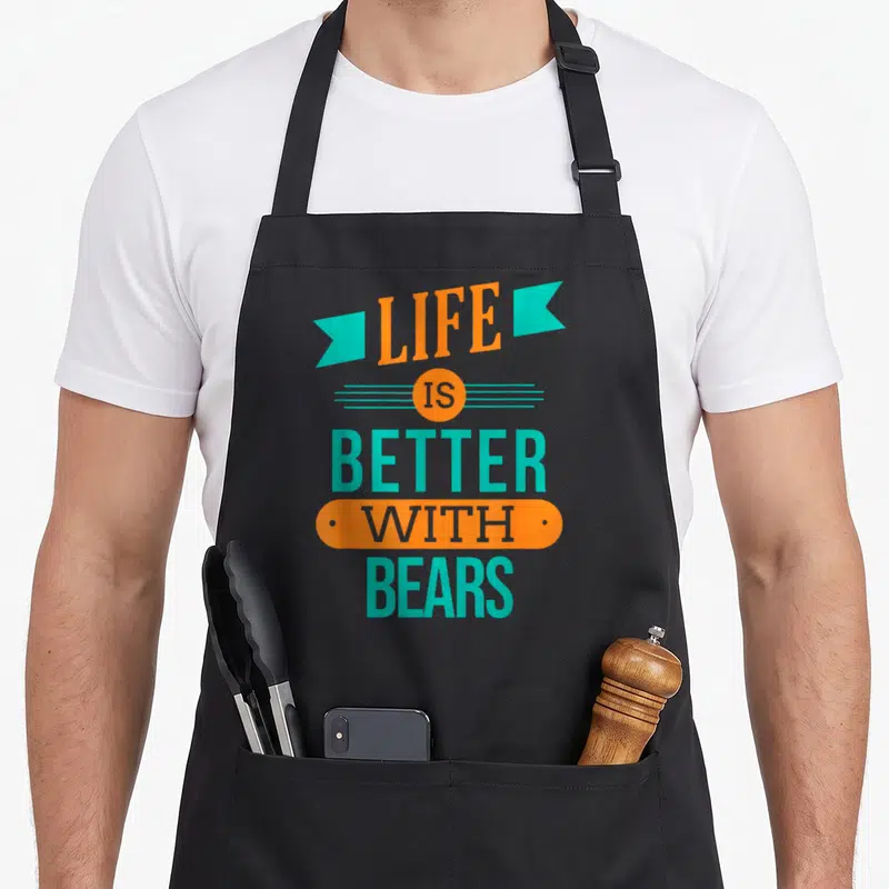 Tablier de cuisine noir avec inscription Life is better with bears en orange et turquoise sur fond uni.
