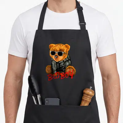 Tablier de cuisine noir avec ourson en veste noire, lunettes de soleil et texte Bad Boy en rouge