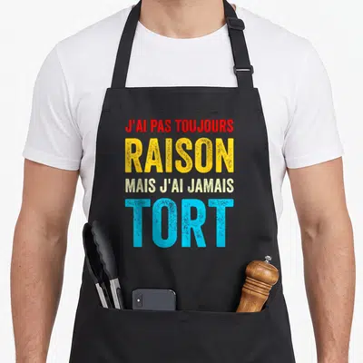 Tablier de cuisine noir avec une inscription colorée et humoristique en typographie graphique.