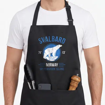 Tablier de cuisine noir avec illustration vintage d'ours polaire sur fond circulaire bleu et texte Svalbard Norvège