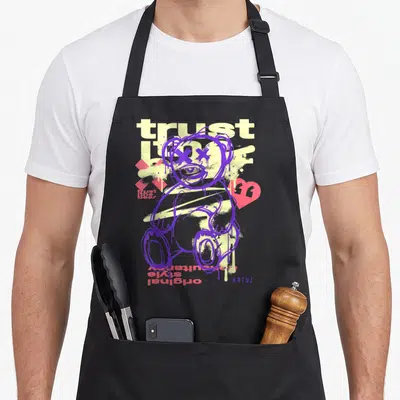 Tablier de cuisine noir avec ours violet graffiti, texte trust love et cœur rose sur fond jaune.