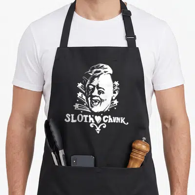 Tablier de cuisine noir avec illustration blanche du visage Sloth Chunk entouré d'étoiles et du texte SLOTH CHUNK