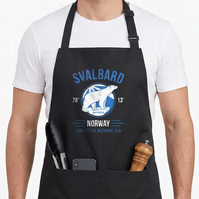Tablier de cuisine noir avec illustration d'ours polaire blanc et texte Svalbard Norway en bleu et blanc.