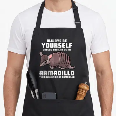 Tablier de cuisine noir avec illustration de tatou et texte blanc Always be yourself unless you can be an armadillo