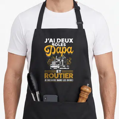 Tablier de cuisine noir avec inscription Papa et routier et illustration de camion blanc sur fond orange.