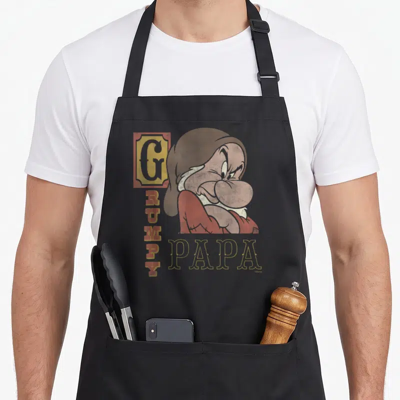 Tablier de cuisine noir avec un Grumpy Papa aux bras croisés et une expression faciale mécontente.