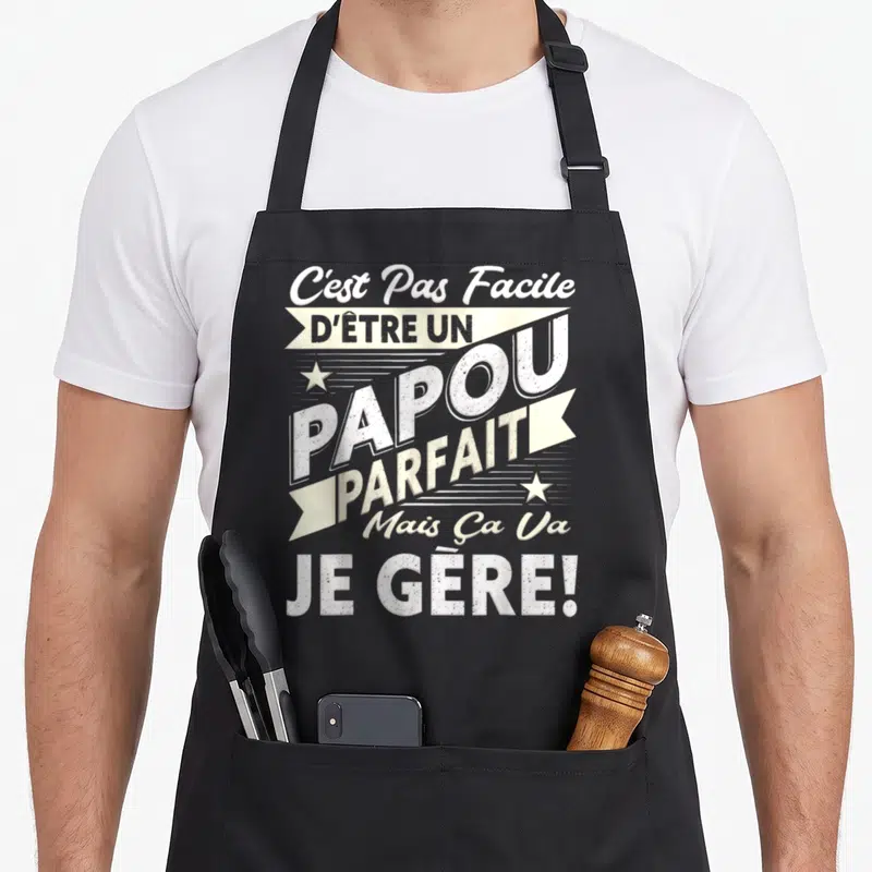 Tablier de cuisine noir avec typographie blanche et crème proclamant C'est Pas Facile dEtre un Papou Parfait Je Gere.