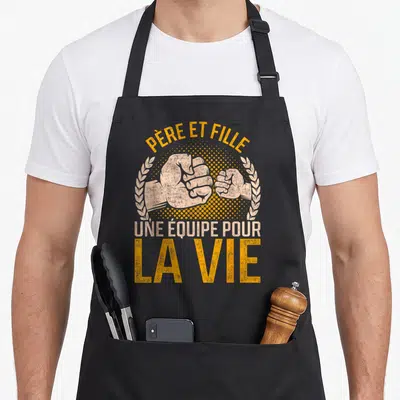 Tablier de cuisine noir avec deux poings se serrant et le texte Père et Fille une équipe pour la vie.