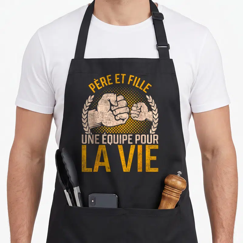 Tablier de cuisine noir avec deux poings se serrant et le texte Père et Fille une équipe pour la vie.
