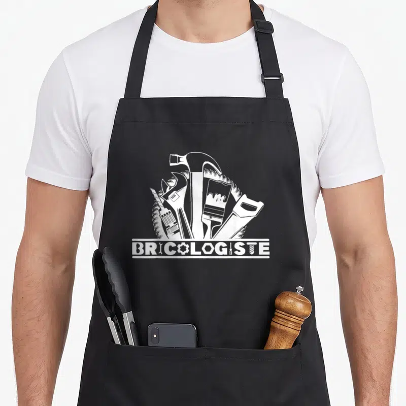 Tablier de cuisine noir avec illustration blanche d'outils et le mot BRICOLOGISTE stylisé.