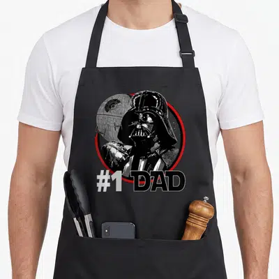 Tablier de cuisine noir avec illustration de Darth Vader, Death Star et texte #1 DAD en blanc et noir.