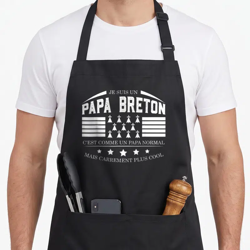 Tablier de cuisine noir avec inscription Je Suis Un Papa Breton et drapeau gwer mod blanc stylisé.