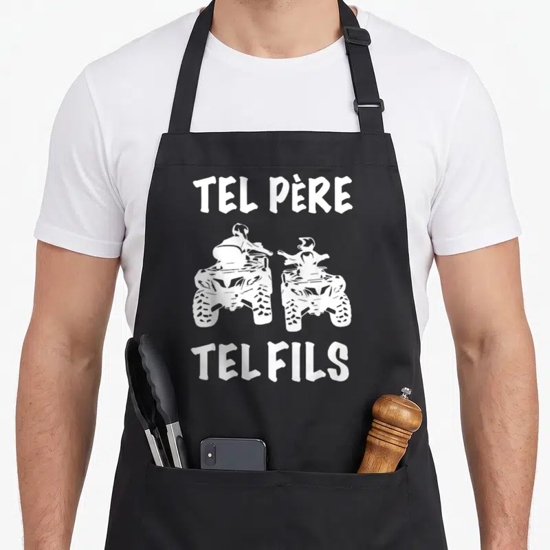 Tablier de cuisine noir avec l'inscription Tel Père Tel Fils et deux quads antenne cubique dessinés en blanc sur le devant.