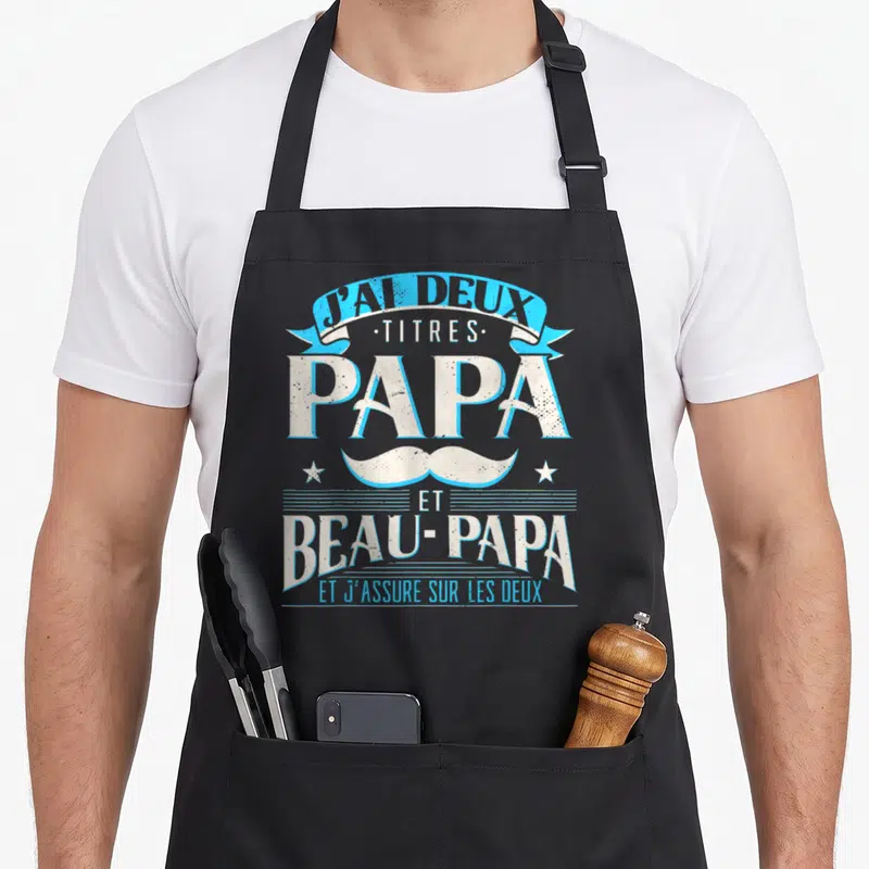 Tablier de cuisine noir avec inscription J'ai deux titres Papa et Beau-Papa et moustache bleue.