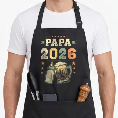 Tablier de cuisine noir avec inscription Papa 2026, illustration biberon et bière vintage aux couleurs pastel.