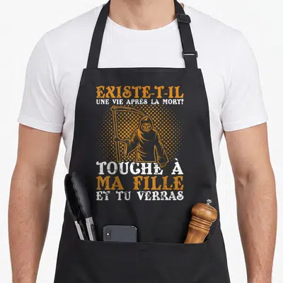 Tablier de cuisine noir avec illustration du diable et texte orange blanc sur fond uni.