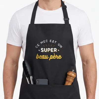 Tablier de cuisine noir avec l'inscription Ce mec est un super beau père en typographie blanche et jaune.