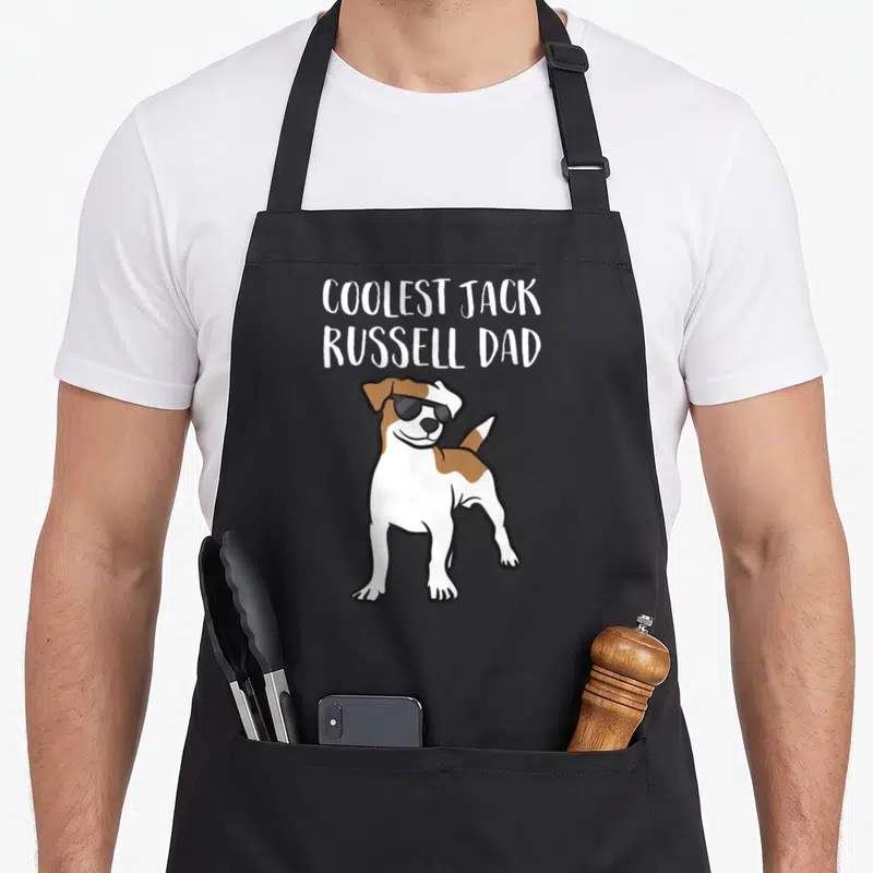 Tablier de cuisine noir avec illustration d'un Jack Russell portant des lunettes de soleil et un texte en anglais au-dessus.