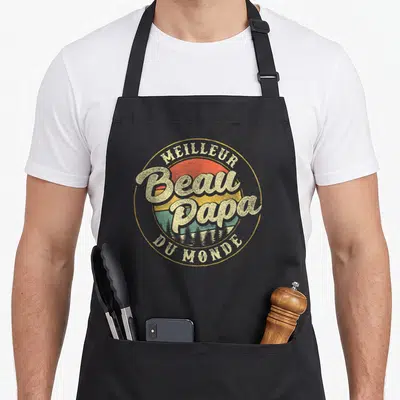 Tablier de cuisine noir avec logo rond vintage Meilleur Beau Papa du Monde sur fond de soleil et forêts.