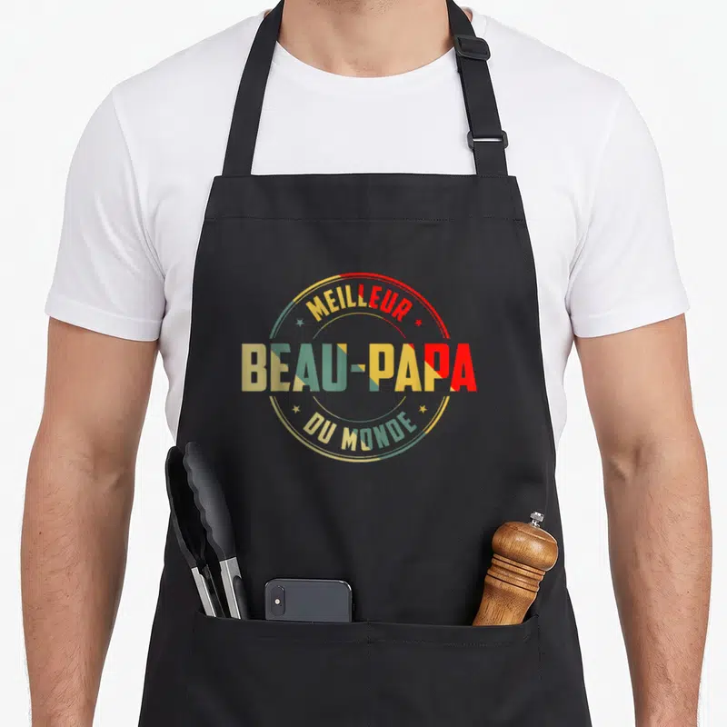 Tablier de cuisine noir avec l'inscription Meilleur Beau-Papa Du Monde en lettres multicolores et cercles décoratifs.