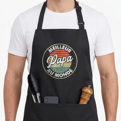Tablier de cuisine noir avec logo circulaire retro affichant Meilleur Papa au Monde en lettres blanches et couleurs pastel.