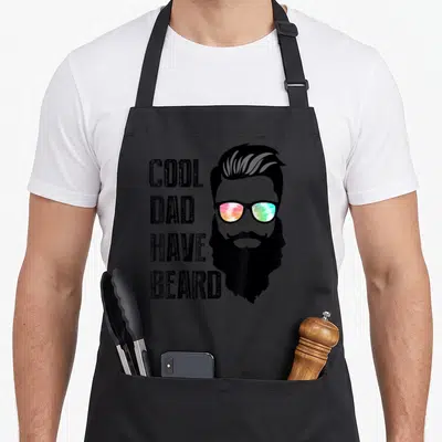 Tablier de cuisine noir avec silhouette barbu lunettes tie-dye et texte anglais distordu.