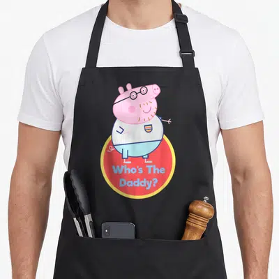 Tablier de cuisine noir avec Papa Pig en lunettes et le texte Who's The Daddy sur fond rouge.