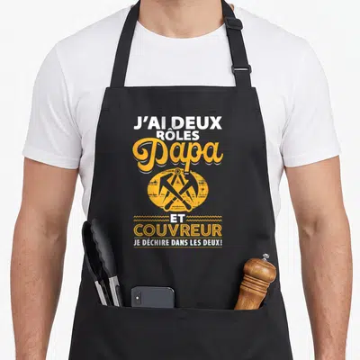 Tablier de cuisine noir avec inscription Papa et couvreur et outil de mesure orange croisés.