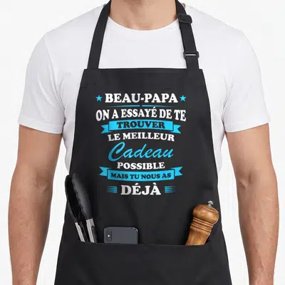 Tablier de cuisine noir avec inscription blanche et bleue disant Beau-papa on a essayé de te trouver le meilleur cadeau possible mais tu nous as déjà.
