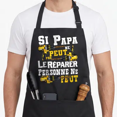 Tablier de cuisine noir avec inscription blanche et jaune Si papa ne peut pas le réparer personne ne peut surmonté de trois perceuses électriques.