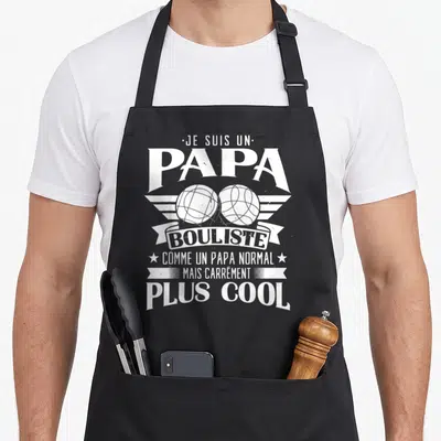 Tablier de cuisine noir avec inscription Je suis un papa bouliste et deux boules de pétanque stylisées en blanc.