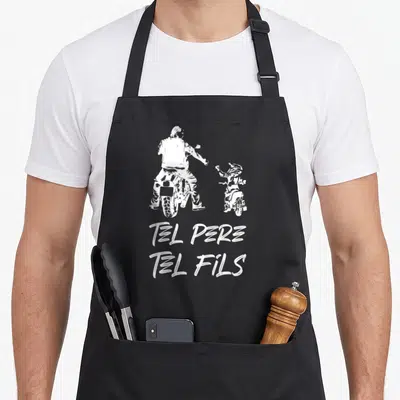 Tablier de cuisine noir avec illustration blanche d'un homme et un enfant sur motos cross et texte Tel Père Tel Fils.