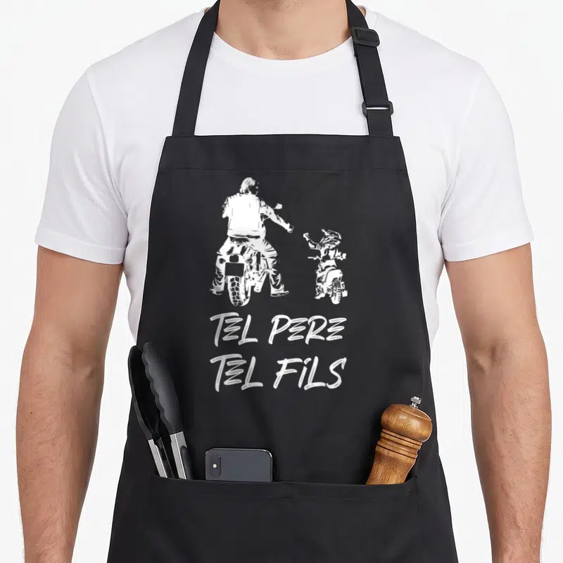 Tablier de cuisine noir avec illustration blanche d'un homme et un enfant sur motos cross et texte Tel Père Tel Fils.