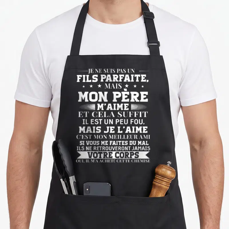 Tablier de cuisine noir avec inscription blanche humoristique sur le thème familial et paternel.