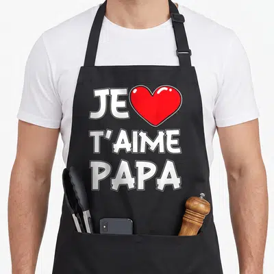 Tablier de cuisine noir avec l'inscription Je t'aime Papa et un grand cœur rouge au centre du motif imprimé.