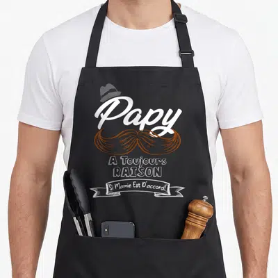 Tablier de cuisine noir avec le texte Papy a toujours raison, une moustache brune et un chapeau gris.