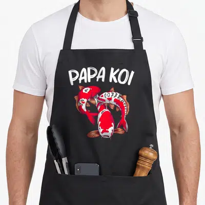 Tablier de cuisine noir avec trois poissons koi rouges et blancs et le texte Papa Koi en blanc.