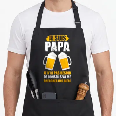 Tablier de cuisine noir avec deux verres de bière s'entrechoquant et texte humoristique en blanc et orange sur fond uni.