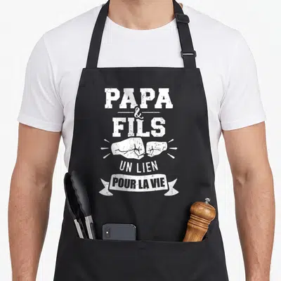 Tablier de cuisine noir avec inscription Papa et Fils un lien pour la vie et illustration de poings.