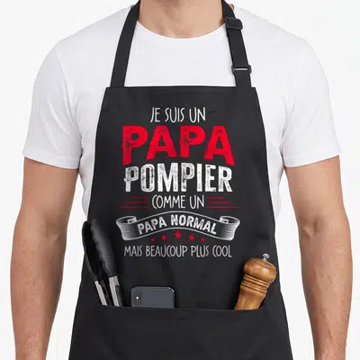 Tablier de cuisine noir avec inscription Je suis un papa pompier comme un papa normal mais beaucoup plus cool en rouge et blanc.